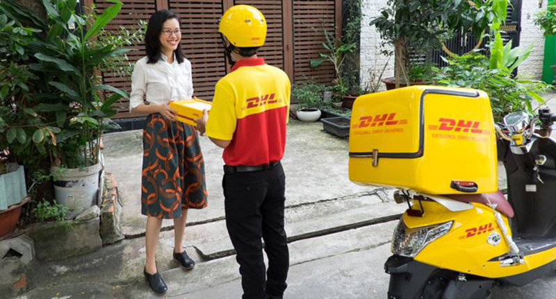 Cận cảnh nhân viên vận chuyển DHL giao hàng cho khách bằng xe máy điện
