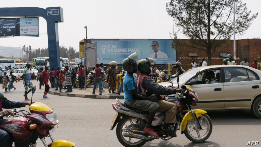 Một hành khách đi trên một chiếc taxi moto chạy bằng nhiên liệu ở Kigali, Rwanda