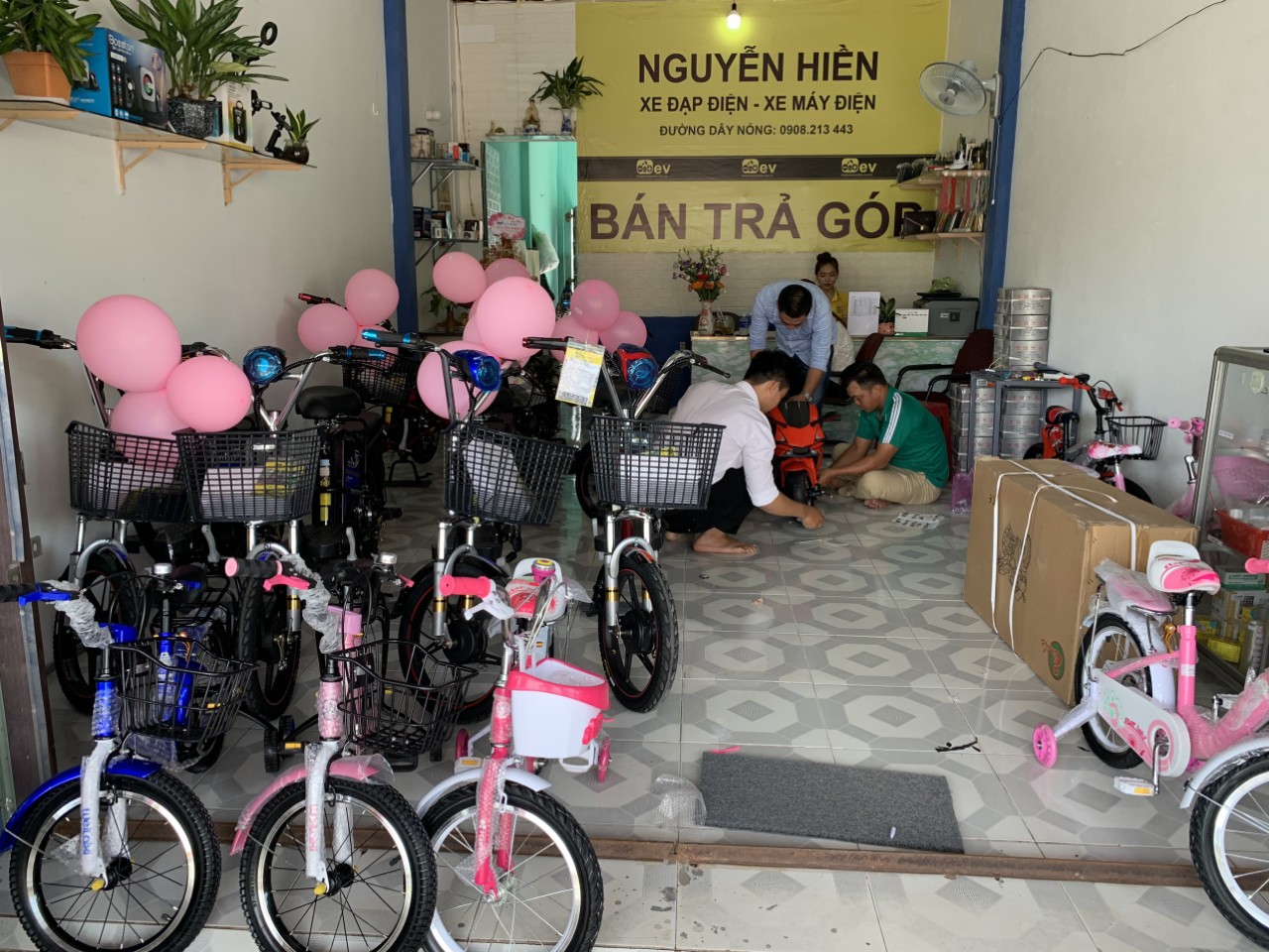 Nhân viên đang lắp ráp xe điện mini cho khách Nhân viên đang lắp ráp xe điện mini cho khách